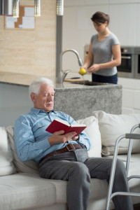 man reading, caretaker in background